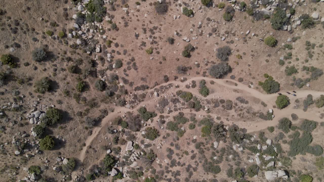 un drone de arriba hacia abajo captura a los excursionistas que caminan por los desiertos del sur de california.