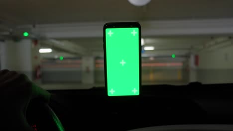 maqueta de pantalla verde de un teléfono inteligente dentro de un coche durante la conducción.
