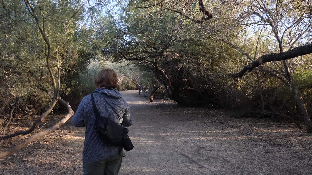 Red hair man littering a disposable vape while walking in a park.