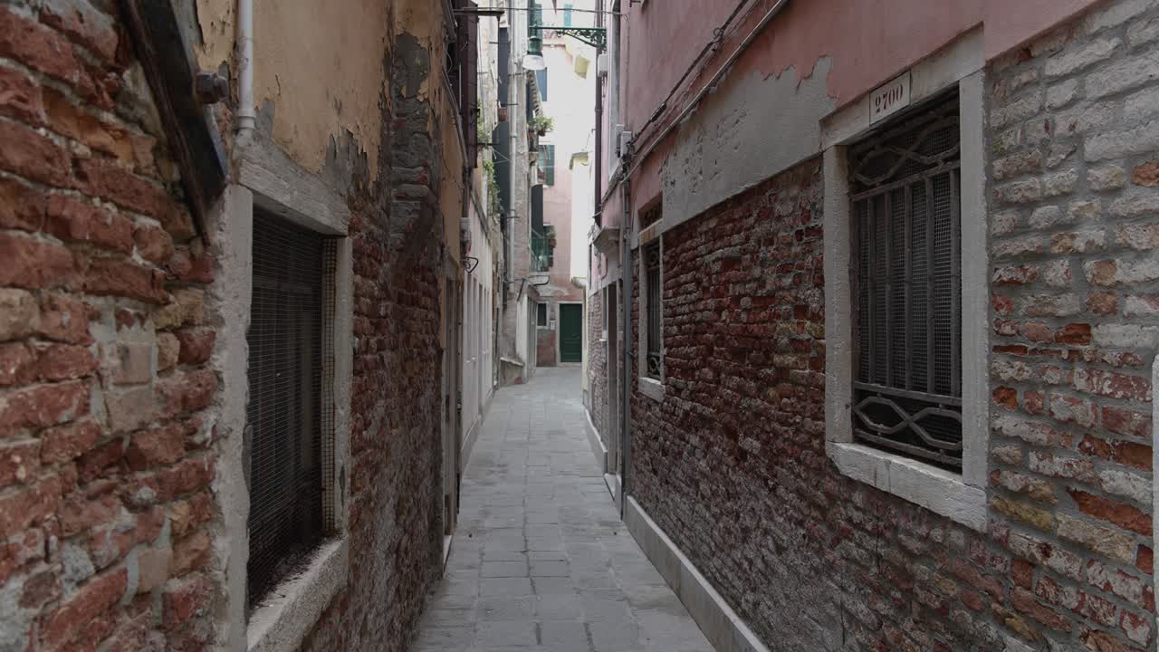 Narrow red brick building with cobblestone alley walkway path, static