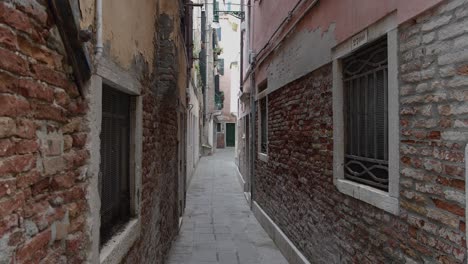 narrow red brick building with cobblestone alley walkway path, static