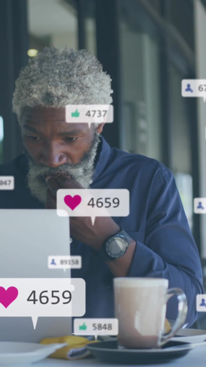 Animation of social media icons and numbers over african american man using laptop