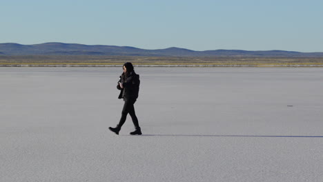 female traveler enjoys yerba mate while exploring remote salt desert in argentina, cultural and nature retreat