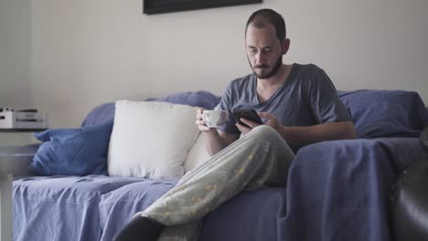 Mann,-Der-Morgens-Seinen-Ersten-Kaffee-Auf-Der-Couch-Trinkt,-Bevor-Er-Zu-Hause-Arbeitet