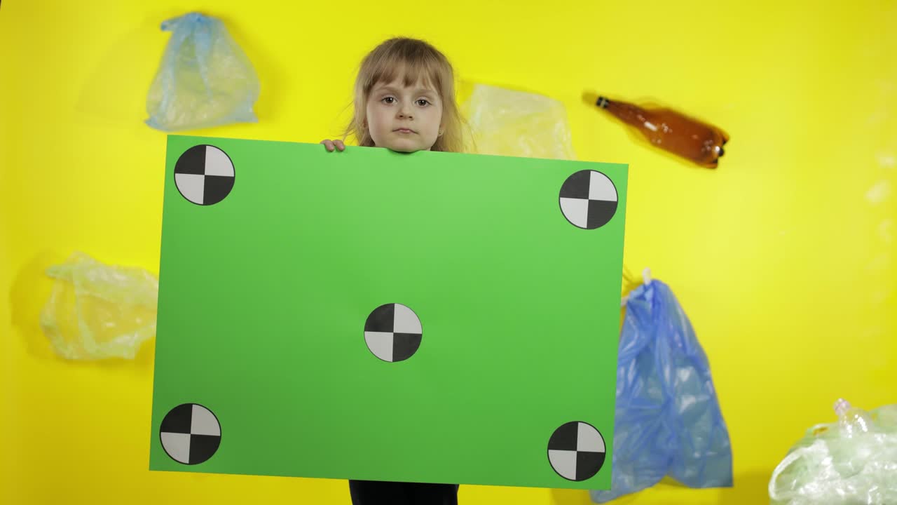 Ragazza attivista che tiene un poster chroma key con punti di tracciamento. Inquinamento ambientale da plastica e rifiuti