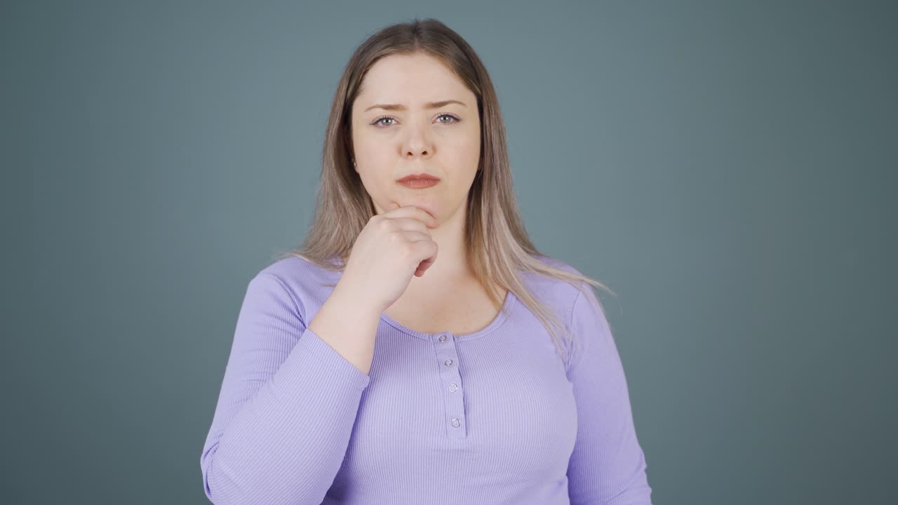 una joven pensativa hacia la cámara.