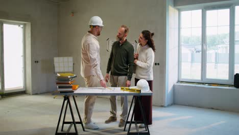 equipo de construcción midiendo paredes en un nuevo hogar