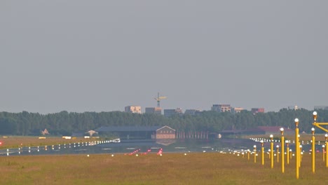 video of an airplane landing on the runway from the edge of it.