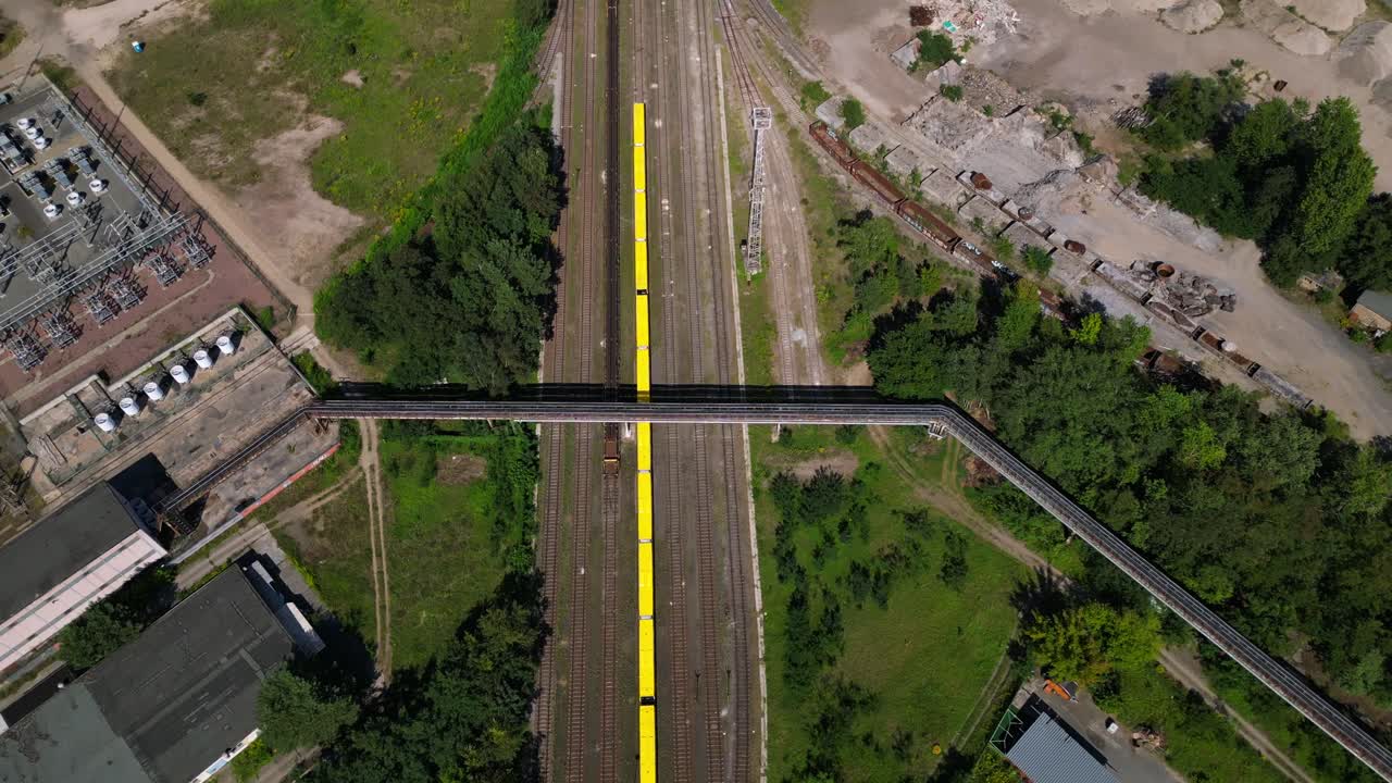 Hennigsdorf steel factory with chimneys, warehouses, railway, near river and forest in summer. Amazing aerial view flight tilt up drone