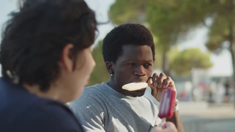 african american man eating ice cream with his female friend