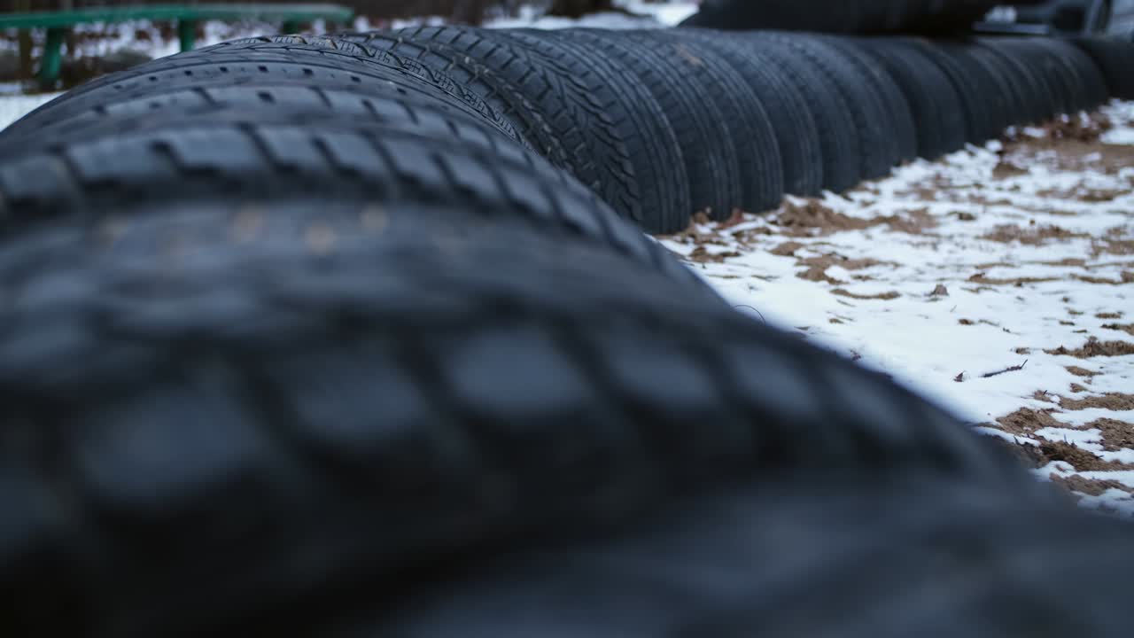 valla de barrera alrededor del patio de recreo o campo de juego hecha de neumáticos de automóviles negros enterrados en el suelo