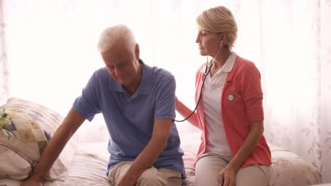 Female-doctor-checking-a-senior-man-with-stethoscope