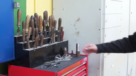 Slow-motion-shot-of-an-engineer-removing-a-file-from-a-tool-bench-in-an-industry-workshop-in-Stornoway-on-the-Isle-of-Lewis,-part-of-the-Outer-Hebrides-of-Scotland