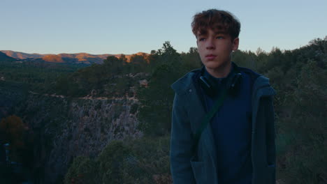 teenager on mountain top at sunset