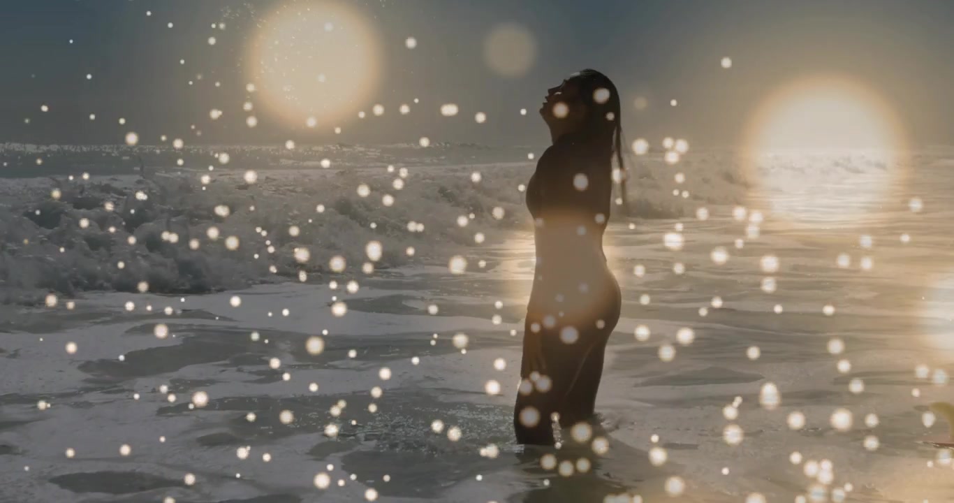Donna che si sciacqua i capelli tra le onde, si volta e guarda l'orizzonte, con un effetto bokeh che sovrappone la silhouette per il benessere.