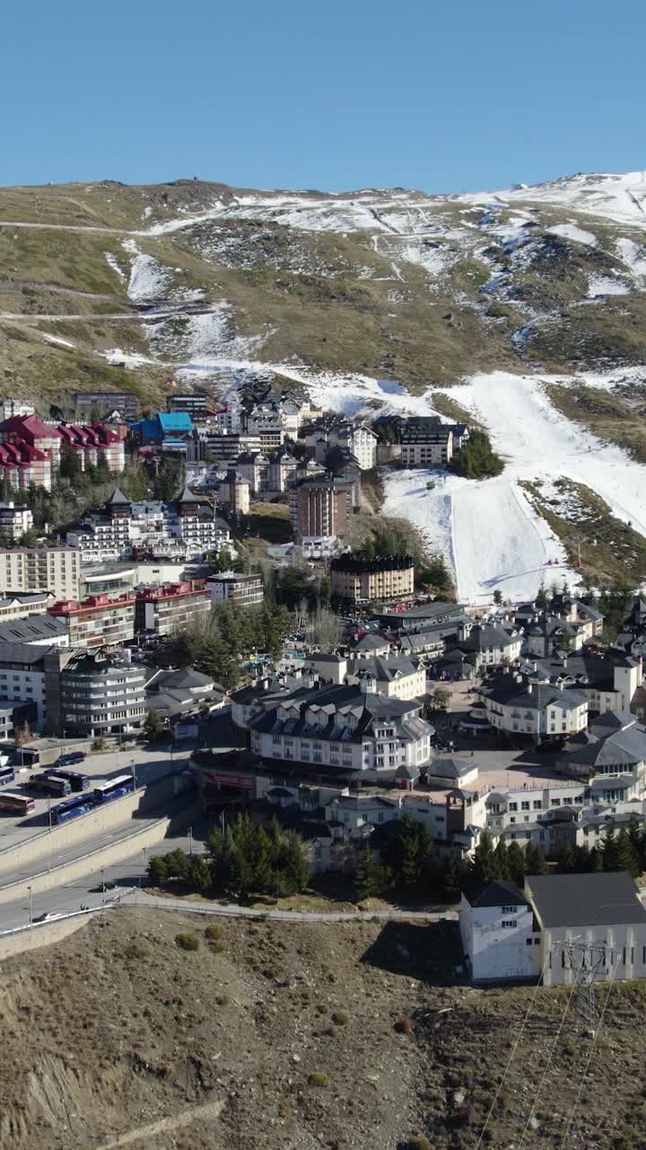 Vertikal droneoptagelse i fugleperspektiv af Sierra Nevada skisportssteds panorama-vinterlandskab i Spanien