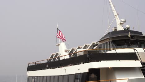 bandera estadounidense en la parte superior de un barco que ondea a través de la brisa costera del océano pacífico en san diego, california