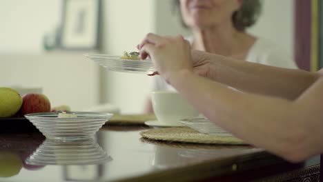 un primer plano de una mujer esparciendo mantequilla sobre el pan.
