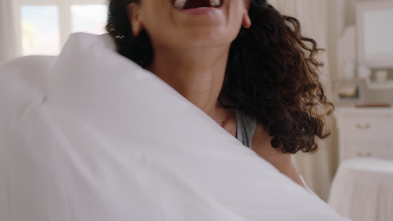 bellissima giovane donna che nasconde il viso con le coperte sentendosi timida sorridendo godendo l'attenzione giocosa nel letto 4k footage pov