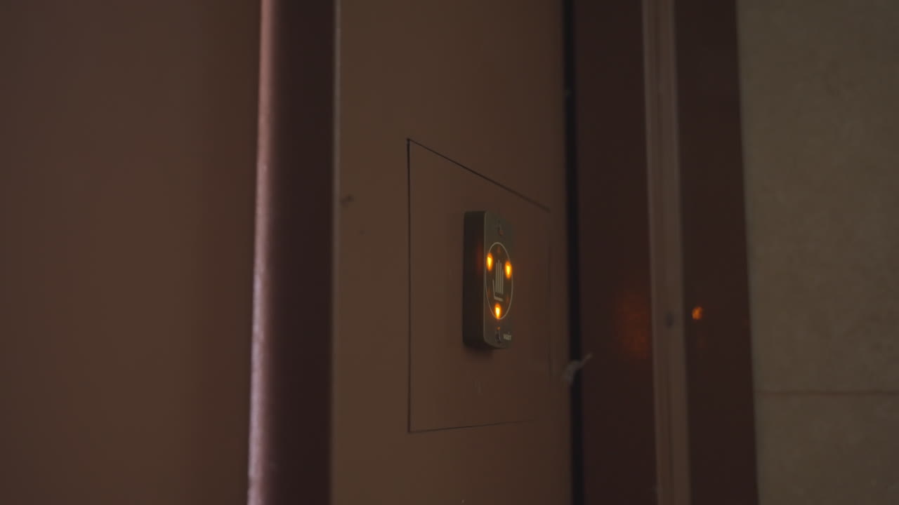 부드러운 블러 프레임은 자동 보안문이 닫히는 모습을 보여주고, 센서 시스템은 복도로 외부의 강한 빛을 줄이며, 흐릿한 파스텔 색조는 움직임, 폐쇄, 개인 정보 보호, 입구의 문턱 순간을 암시해요.