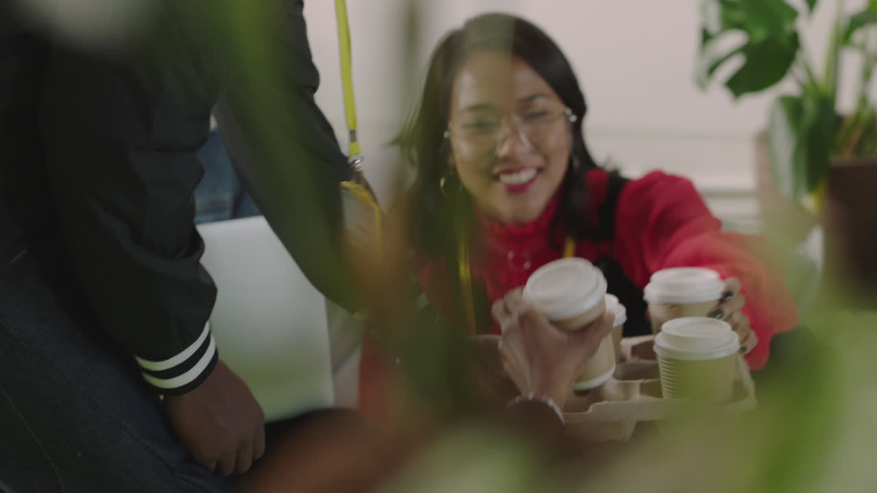 젊은 사업가 학생들은 정보를 공유하고 노트북 컴퓨터를 사용하여 그룹 프로젝트에 대한 아이디어를 브레인스토밍하고 편안한 다채로운 사무실 작업장에서 커피를 마시고 있습니다.