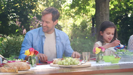 Three-generation-white-family-having-lunch-in-the-garden