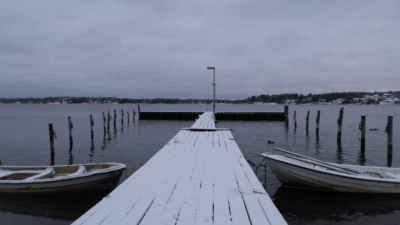 pontón y barco cubierto de nieve con pato en el lago