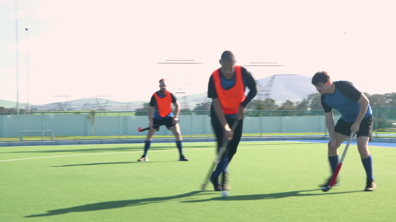 Playing field hockey, male athletes competing in outdoor sports match