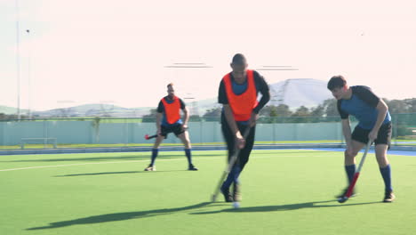 playing field hockey, male athletes competing in outdoor sports match