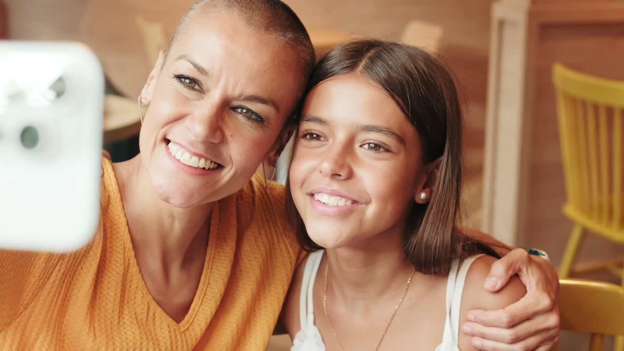 Mother And Daughter Enjoying Cafe And Phone