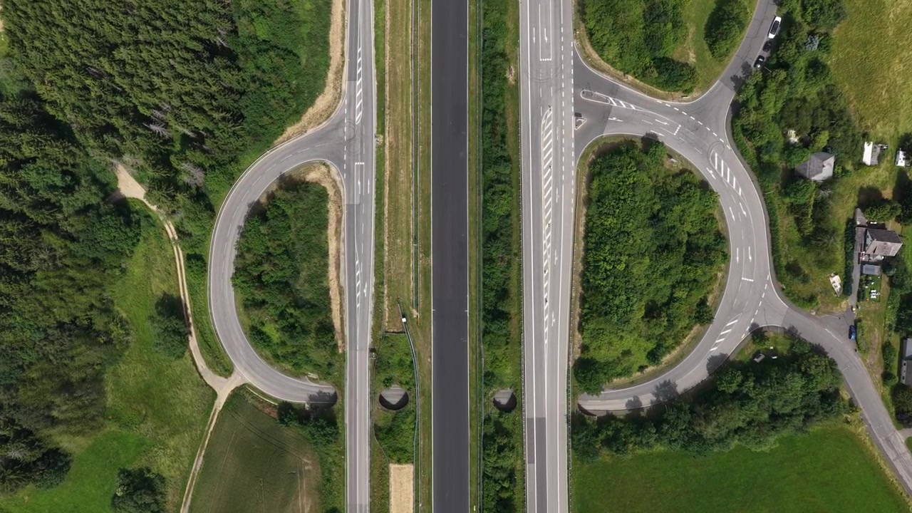 Aerial view of the Nürburgring race circuit showing a long straight and track crossing, with motorsport infrastructure and asphalt racing surface.