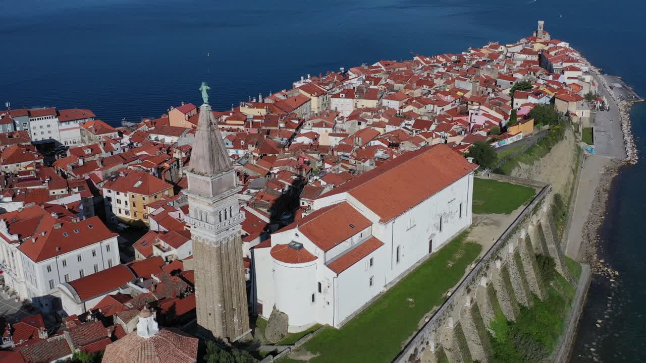 tiro de drone de la iglesia de san jorge de pie en la colina en la ciudad costera de piran, eslovenia