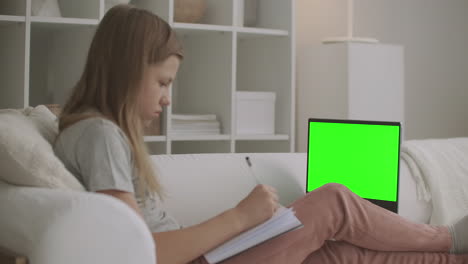 Teenager-Mädchen-Lernt-Online-Von-Zu-Hause-Aus-Und-Sieht-Sich-Online-Lektionen-Auf-Einem-Laptop-Mit-Grünem-Bildschirm-Für-Chroma-Key-Technologie-An