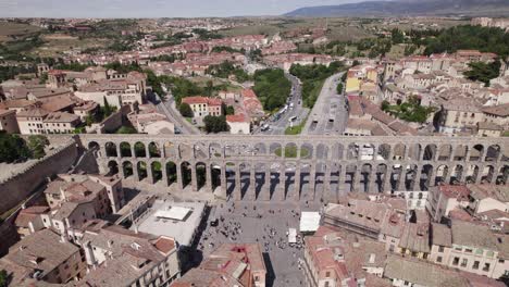 Aerial:-Majestic-ancient-Roman-Aqueduct-of-Segovia,-Spain---Plaza-Azoguejo
