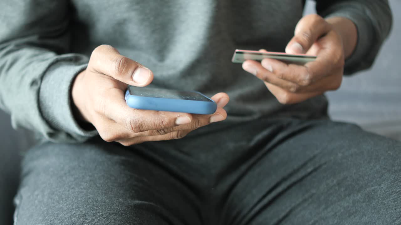 스마트폰과 신용카드를 사용하여 온라인 결제를 하는 사람