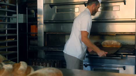 baker removing freshly baked bread bun from the oven 4k