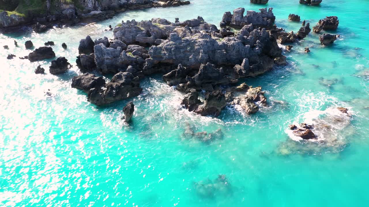 Veduta aerea di rocce appuntite in acque turchesi vicino a un'isola tropicale