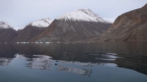 colinas cubiertas de nieve y aguas frías de fiordos, svalbard, noruega
