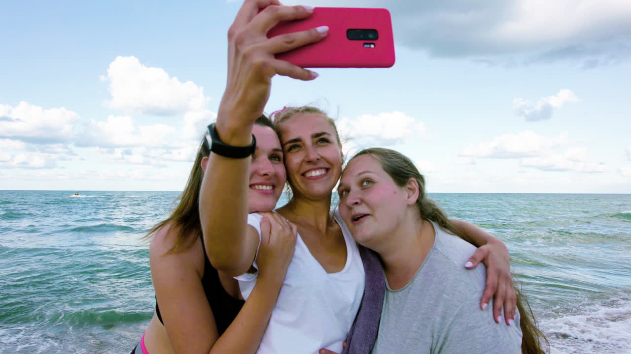 mujeres tomando selfies en la playa.