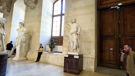 people exploring statues in the louvre museum