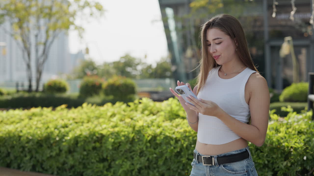 Woman using phone outdoors in a park
