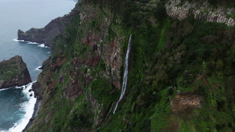 waterfall flowing down the cliffs in rocha do navio park to the sea in madeira island, portugal