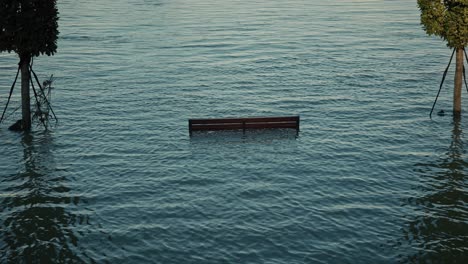 submerged bench is partially visible amidst floodwaters, emphasizing scale of budapest flood in 2024