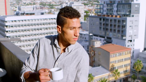 man having coffee in balcony at home 4k