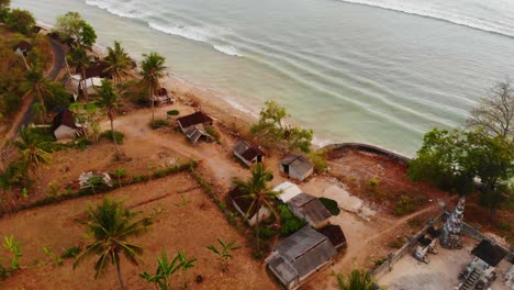 Small-local-huts-on-Nusa-Penida-Indonesia-during-sunrise,-aerial