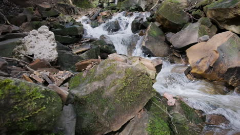 Rapid-water-at-springtime-flowing-down-stream,-filmed-with-a-dolly-shot