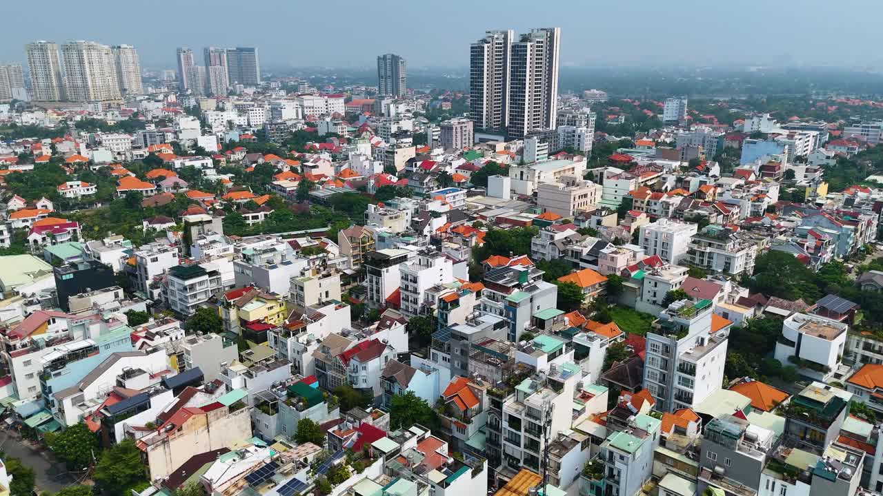 Expansive aerial view of a residential district in Ho Chi Minh City, Vietnam, showcasing a mix of traditional houses, modern high-rises, and urban density.
