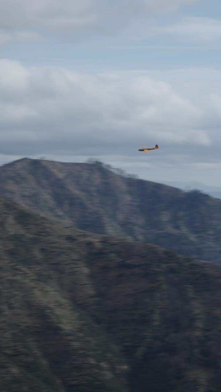 Airplane soaring through the sky above mountains and sea
