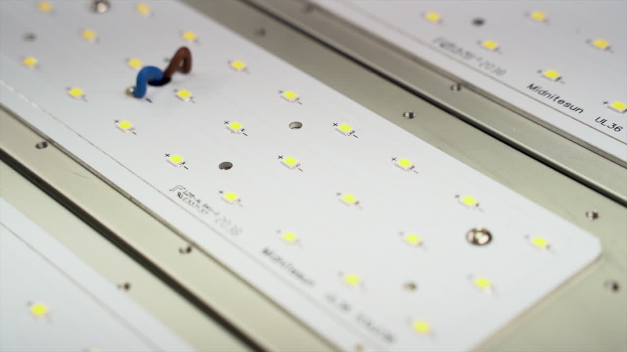 una placa led blanca con un cable azul y rojo conectado a la placa, disparo en órbita