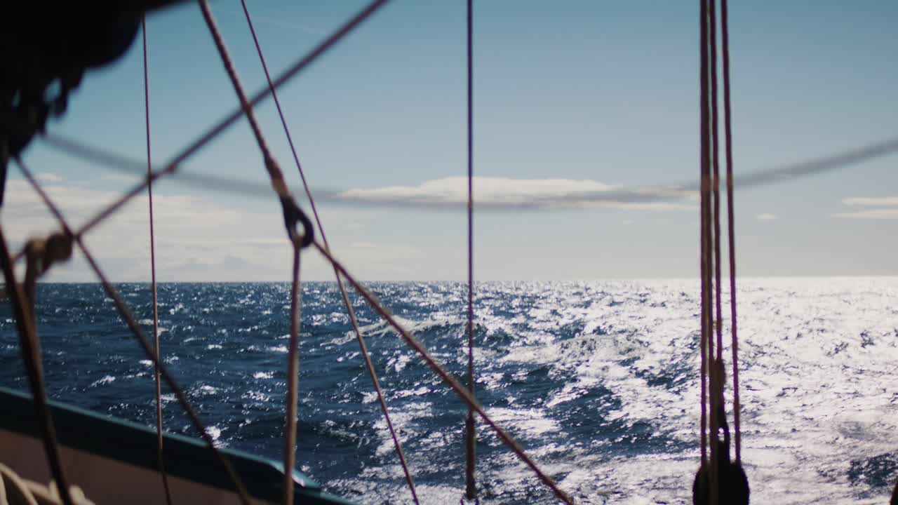 Segeltaue im Vordergrund mit funkelndem Ozean im Hintergrund, sonnenbeschienene Wellen und offener Meerhorizont, nautische Atmosphäre und maritimes Abenteuer-Konzept